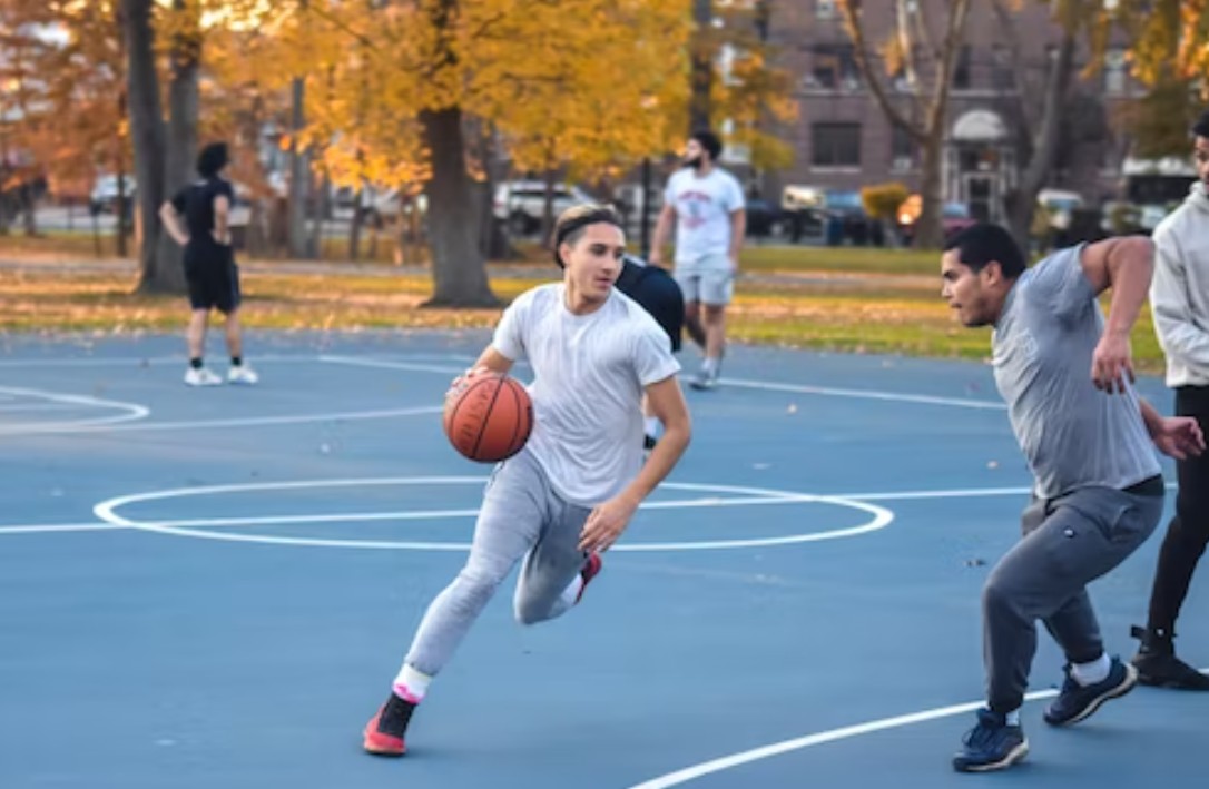 Junge spielt Basketball mit Freund
